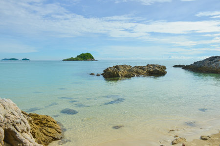 Beautiful crystal clear sea water of Thailand rocky seashore beach with small island at the distance at Sattahip district of Chonburi provinceの写真素材