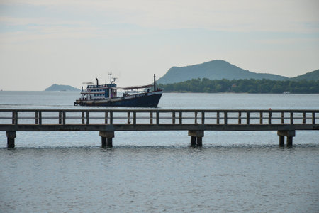 Fisherman boat sailing out to the sea nearby the coast in the early moriningの写真素材
