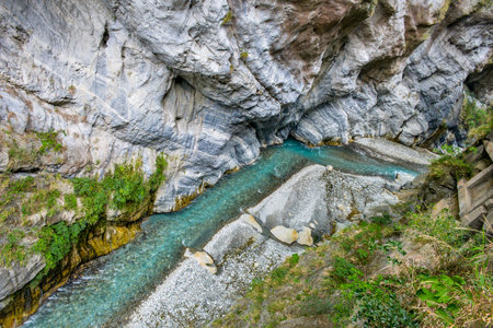 Scenic view of Swallow Grotto Yanzikou Trail with narrow turquoise Liwu River Gorge and high mountain cliff face in Taroko National Park, Xiulin Township, Hualien, Taiwanの写真素材