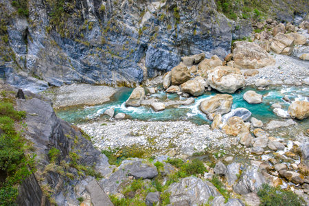 Scenic view of Swallow Grotto Yanzikou Trail with narrow turquoise Liwu River Gorge and high mountain cliff face in Taroko National Park, Xiulin Township, Hualien, Taiwanの写真素材