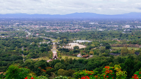 Panoramic aerial view of Chiang Mai city, Thailand, seen from a mountain viewpoint. Lush green landscape with urban development surrounded by mountainsの写真素材