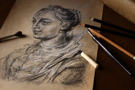 Pencils, brush and white pastel on the background of a copy of a female portrait in retro styleの写真素材