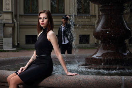 A girl and a guy meet against the background of an ancient fountainの写真素材