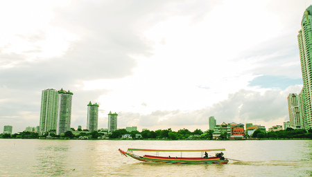 Chao Phraya river Bangkok December 2018 long tail boat unique design characteristic of transportation in Bangkok River boat and ferry boat in Bangkok high rise buiding background old and newの写真素材