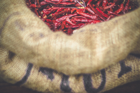 Dried red chilli or chilli cayenne peppers on vintage in nature sack bag background tone.の写真素材