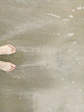 Naked feet at the Beach - Bare feet nature Background.sand beach for relaxation.recharge idea background.の写真素材