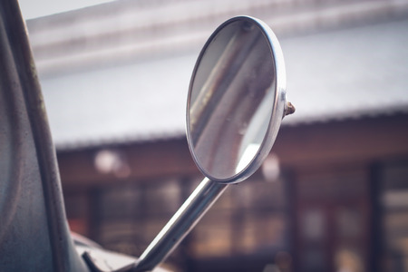 close-up of a driving mirror on a vintage vehicle.old warehouse blur backgroundの写真素材