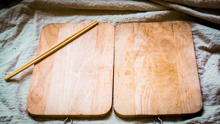 Wooden plate blank with chopsticks, on natural linen cover table on white table, top view .cooking food menu idea backgroundの写真素材