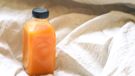 Orange juice in a bottle on linen background. Natural concept idea .health idea