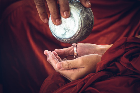 Monk wrinkled hand because of soak in the water . Thailand traditional in New year.の写真素材