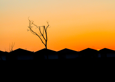 city urban gable roof houses figure silhouette at sunset orange skyの写真素材