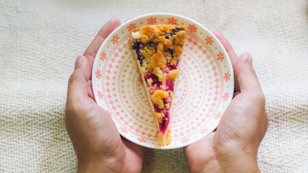 hand hold blueberry cheese cake on plate  morning breakfastの写真素材