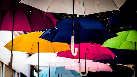 Street decorated with colored umbrellas. Lots of umbrellas coloring the sky in the cityの写真素材
