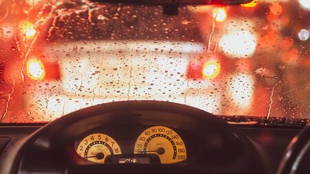 Interior of car when rains. Defocused blur of light on the road in a raining dayの写真素材