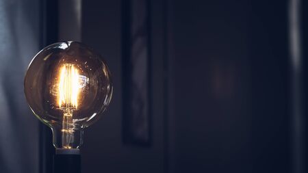 Retro light bulb on dark background with space. Lighting decor macro loft style background. Concept ideaの写真素材