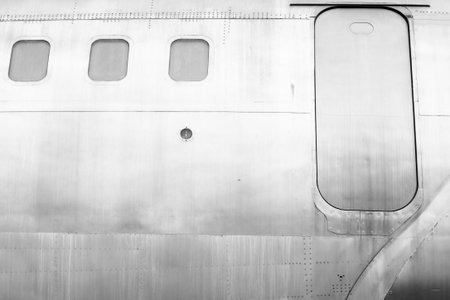 Windows of the white metal surface airplane with emergency exit security escape.