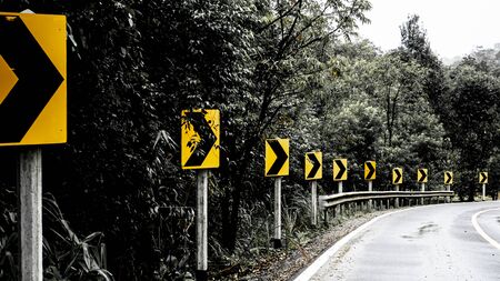 Signal turn right on country road in the woods and mountains. Road trip concept ideaの写真素材