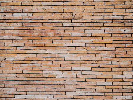 The background of the brick wall in light orange tone . Old red brick wall vintage texture. Grunge stonewall background for text or image.Brick wall of Orange yellow.の写真素材
