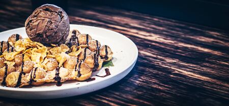 tasty pancakes with chocolate ice cream crispy waffle whipped cream with brownies cherry almond and chocolate syrup on top with corn-flex . summer holiday dessert Menu for kid  .の写真素材