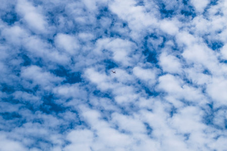small Airplane flying in the blue sky among white clouds and sunlight . Airplane destination...