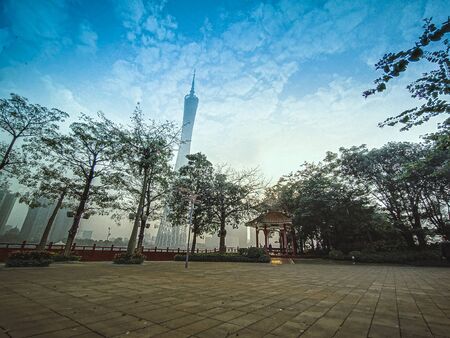 The Canton Tower formally Guangzhou TV Astronomical and Sightseeing. Viewed from the front entrance of Park with traditional Chinese Pavilion. New and old architecture in frame.の写真素材