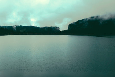 Panorama Mountain Foggy Carpathian Mountains peaks on a foggy autumn morning and lake view. Bucegi...