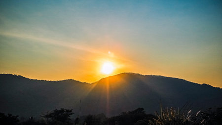 Dramatic sunset or sunrise with sun flare over mountain valley beautiful nature background.