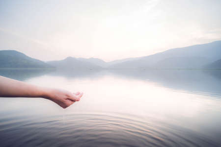 Person Taking Raw Unfiltered Water From A Lake By Handsの写真素材