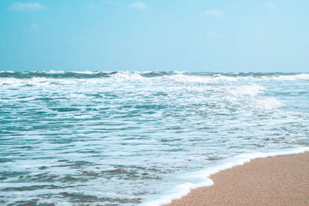 Soft wave with bubble of Blue Ocean on white sand at tropical beach on summer season. Simple beach background for summer. Bubble blue wave from sea to sand on the beach. Summer background.の写真素材