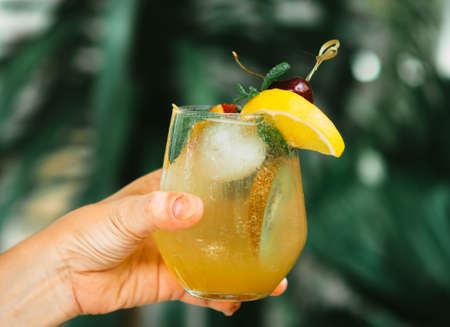 Selective focus hand hold mock tail or cocktail with green nature background.の写真素材