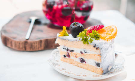 Close up Slice birthday fruit cake in plate violet delicious cream in layerの写真素材