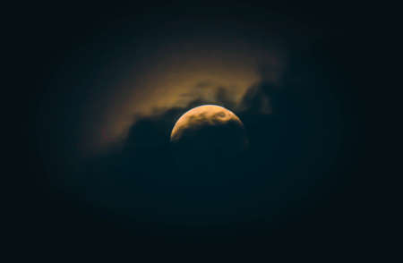 Moon at night partially covered by the cloud. Full moon with clouds dramatic in the night sky.の写真素材
