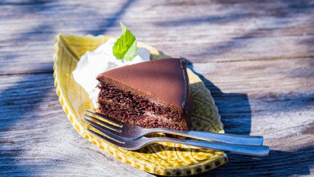 chocolate fudge cake serve with cream on vintage wooden table.の写真素材