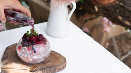 Man pour delicious nonalcoholic Raspberry Mojito which combines fresh raspberries, juicy lime and crisp mint in glassの写真素材