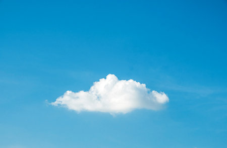 Cute fluffy shape single cloud on clear blue sky background.の写真素材