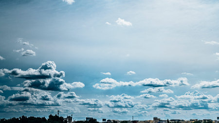Panoramic view of city background blue sky with white huge single floating clouds against blue sky