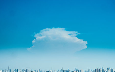 Panoramic view of city background blue sky with white huge single floating clouds against blue skyの写真素材