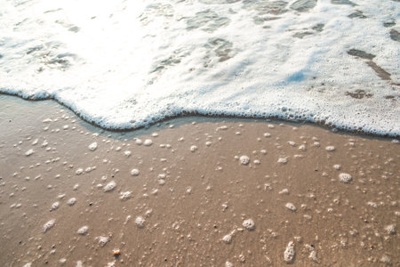 Close Up Wave Sand Beach Sea Foam.  Closeup of sea wave with foam on beach sand. Vacation Summer backgroundの写真素材