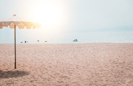 Deckchairs And white Parasol In The Tropical Beach. white umbrella on the beach in summerの写真素材