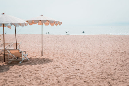 Deckchairs And white Parasol In The Tropical Beach. white umbrella on the beach in summerの写真素材