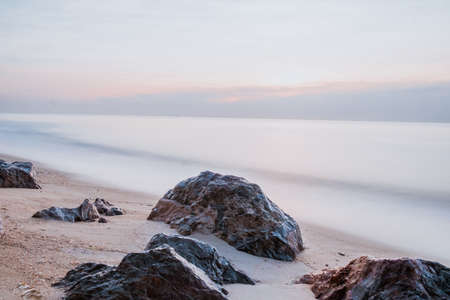 long exposure Sea rocks landscape Magnificent sunrise view at sunrise Romantic atmosphere in peaceful morning at sea. Pink horizon with first hot sun rays.の写真素材