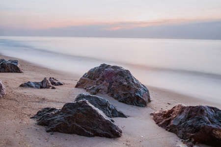 long exposure Sea rocks landscape Magnificent sunrise view at sunrise Romantic atmosphere in peaceful morning at sea. Pink horizon with first hot sun rays.の写真素材