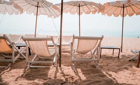 Deckchairs And white Parasol In The Tropical Beach. white umbrella on the beach in summer