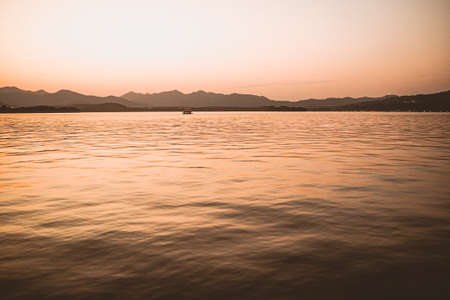 Panorama scenery of Morning fall nature misty foggy scene: forest with trees surrounded by  mist on the water surface of lake with hills andの写真素材