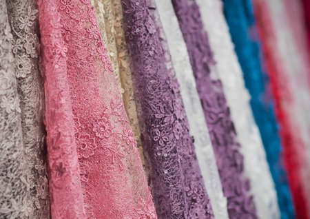 colorful fabric lace fabric rolls in textile shop industry.Rolls of bright colored fabricの写真素材