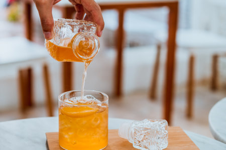 Fresh summer tea soft drink mocktail pour cold beverage in glassの写真素材