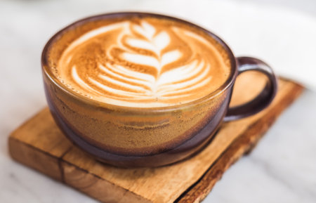 A cup of coffee latte top view with leaf shape foamの写真素材