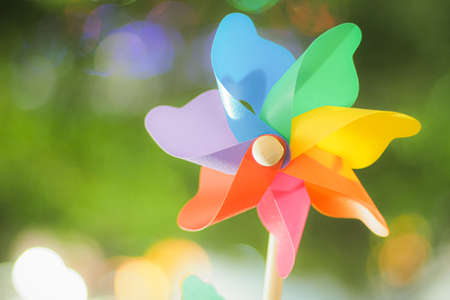 Colorful rainbow pinwheel toy with golden bokeh abstract funny background.の写真素材
