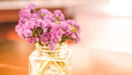 Wild Violet Flowers in Glass Bottle on Rustic Wooden Tableの写真素材