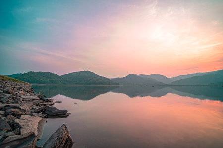 Panorama scenic of mountain lake with perfect reflection at sunrise. beautiful mountain range...